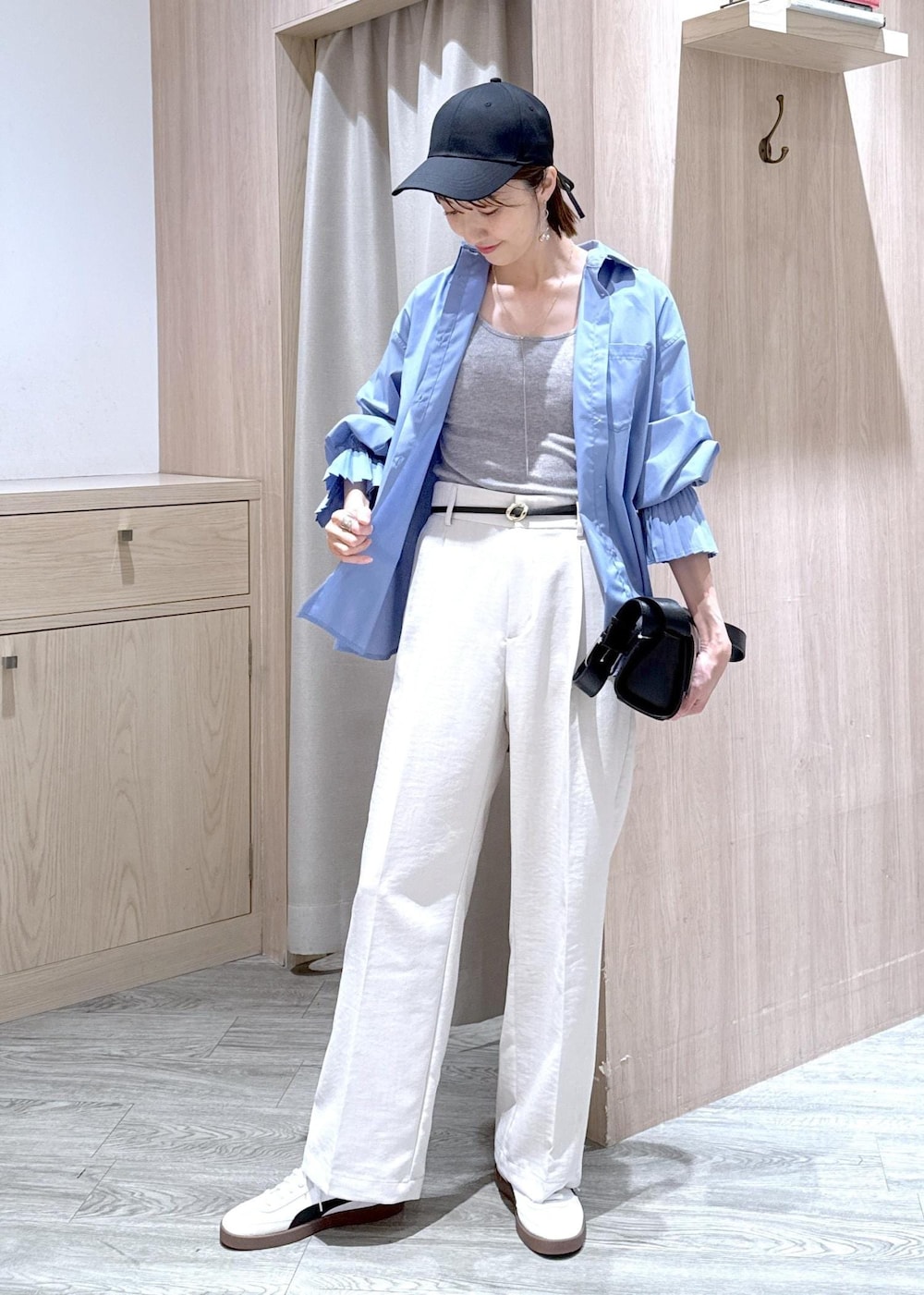 グレー系のタンクトップ、ブルー系のシャツ/ブラウス、ブラック系のショルダーバッグを着用したレディースの春コーディネートの2枚目の写真