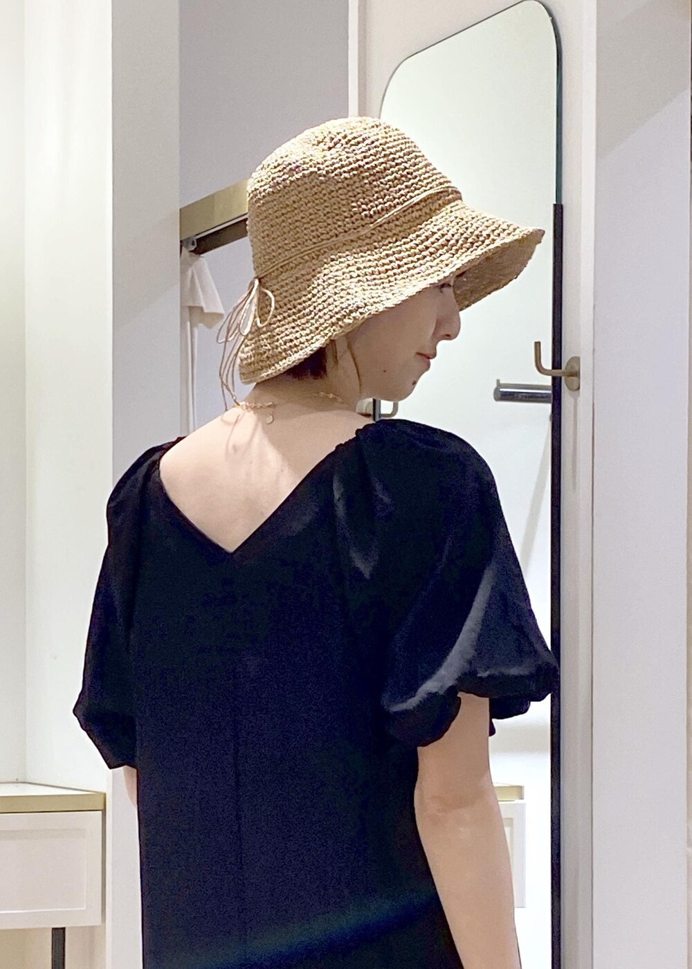 ブラック系のキャミソール、ホワイト系のサンダル、ホワイト系のハンドバッグを着用したレディースの春コーディネートの6枚目の写真