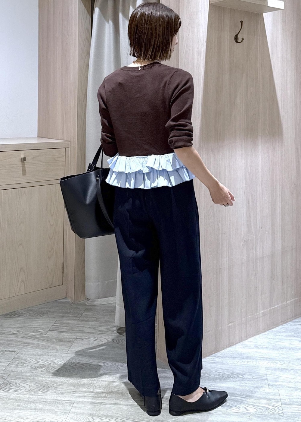 ブラック系のパンプス、ブルー系のその他パンツ、ブラック系のビジネスバッグを着用したレディースの秋コーディネートの3枚目の写真