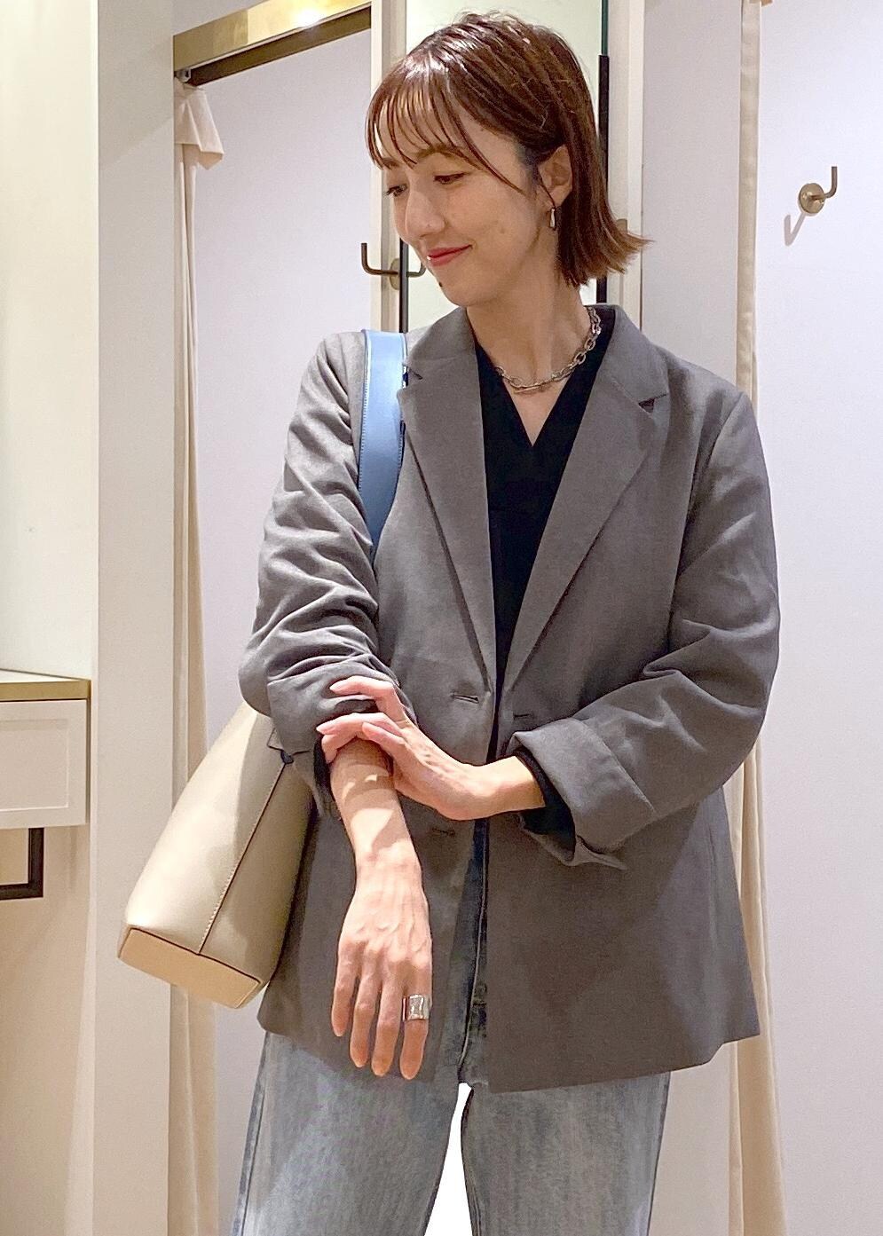 ベージュ系のショルダーバッグ、ブラック系のバレエシューズ、グレー系のテーラードジャケットを着用したレディースの秋コーディネートの6枚目の写真