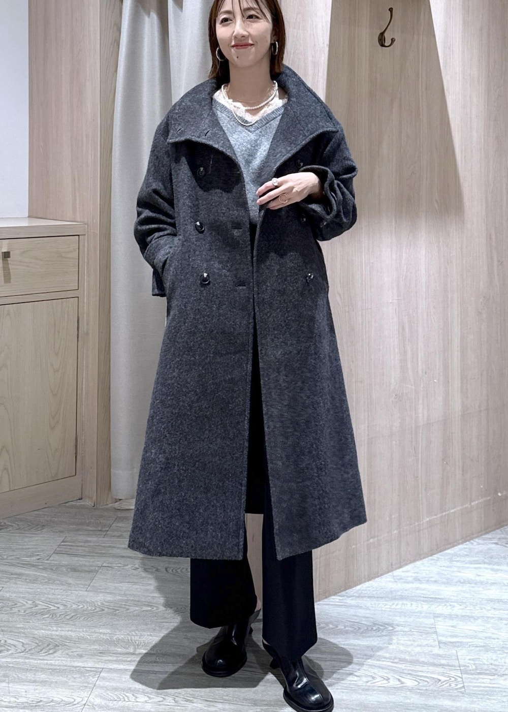 グレー系のニット/セーター、グレー系のその他アウター、ブラック系のその他パンツを着用したレディースの冬コーディネートの9枚目の写真