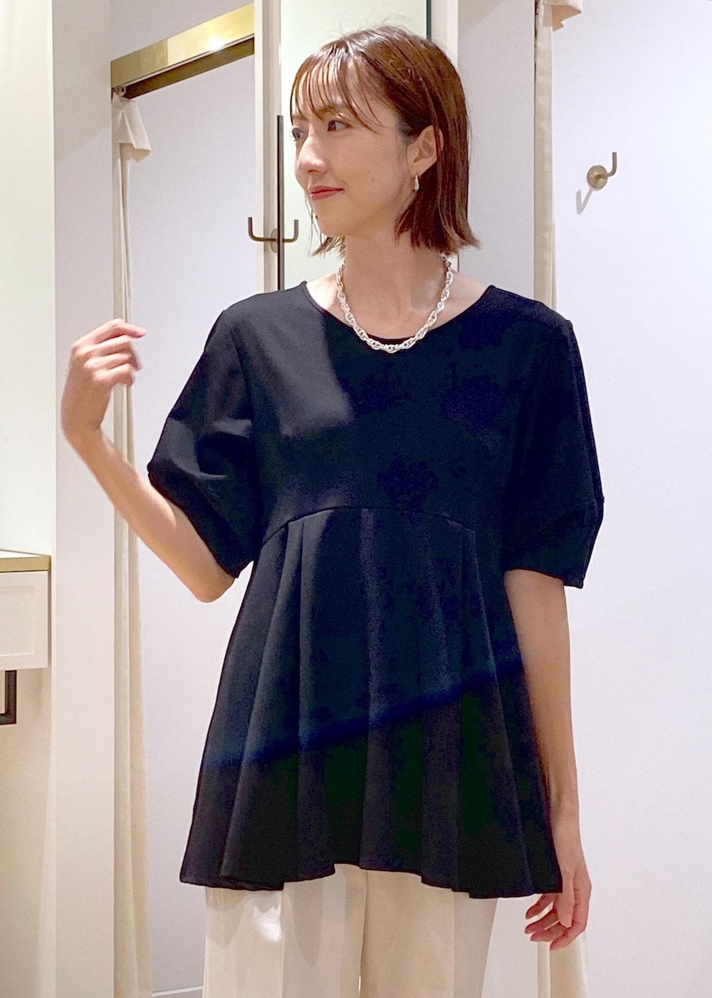 ホワイト系のショルダーバッグ、ホワイト系のスラックス、ブラック系のバレエシューズを着用したレディースの秋コーディネートの7枚目の写真