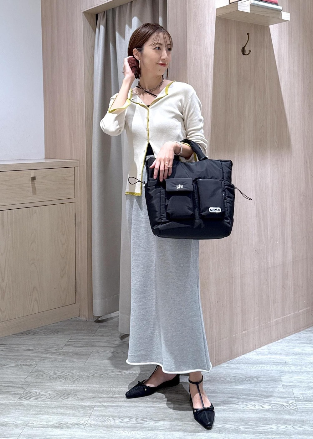 ブラック系のキャミソール、ブラック系のトートバッグ、ベージュ系のカーディガン/ボレロを着用したレディースの秋コーディネートの3枚目の写真