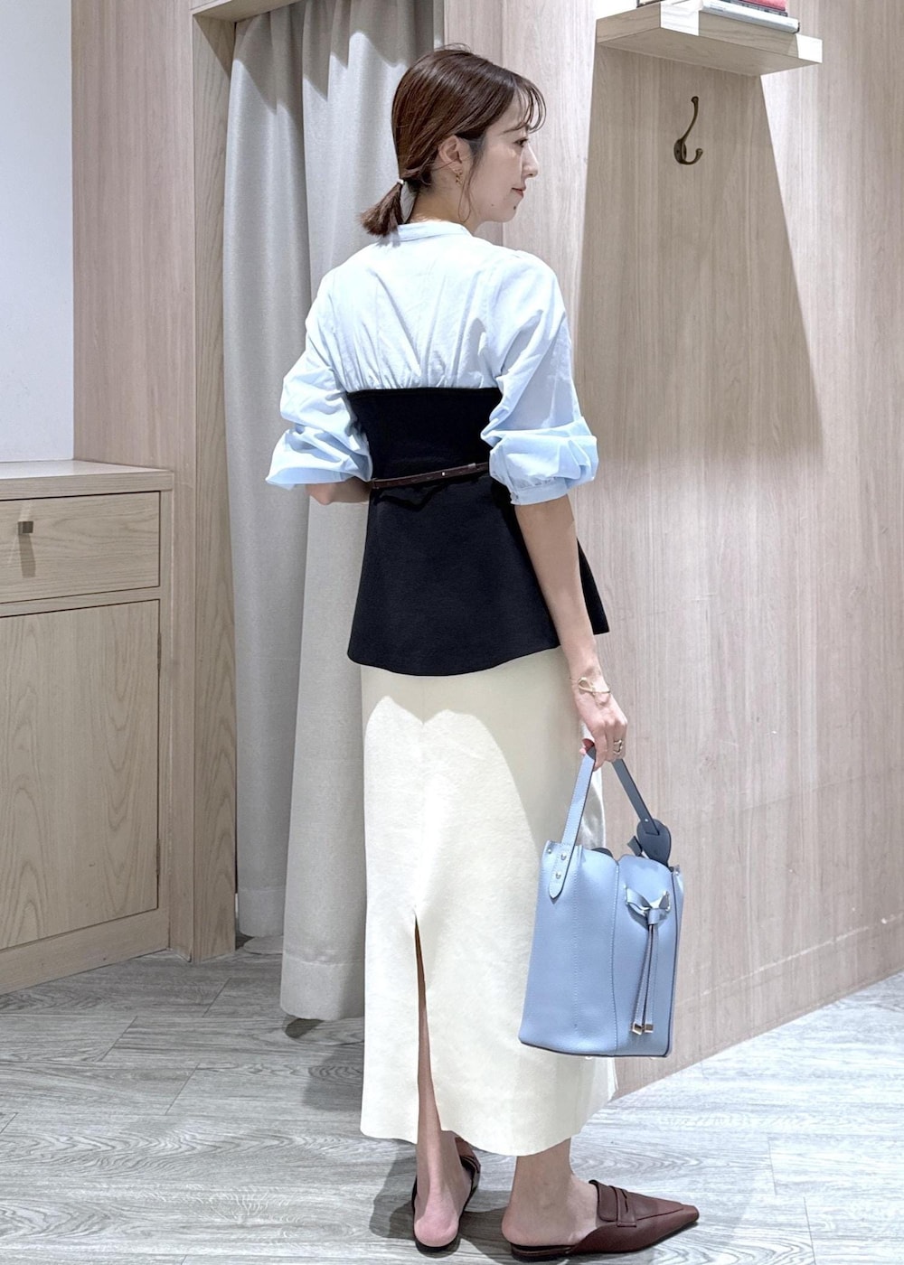 ブルー系のテーラードジャケット、ホワイト系のスカート、ブルー系のショルダーバッグを着用したレディースの春コーディネートの9枚目の写真