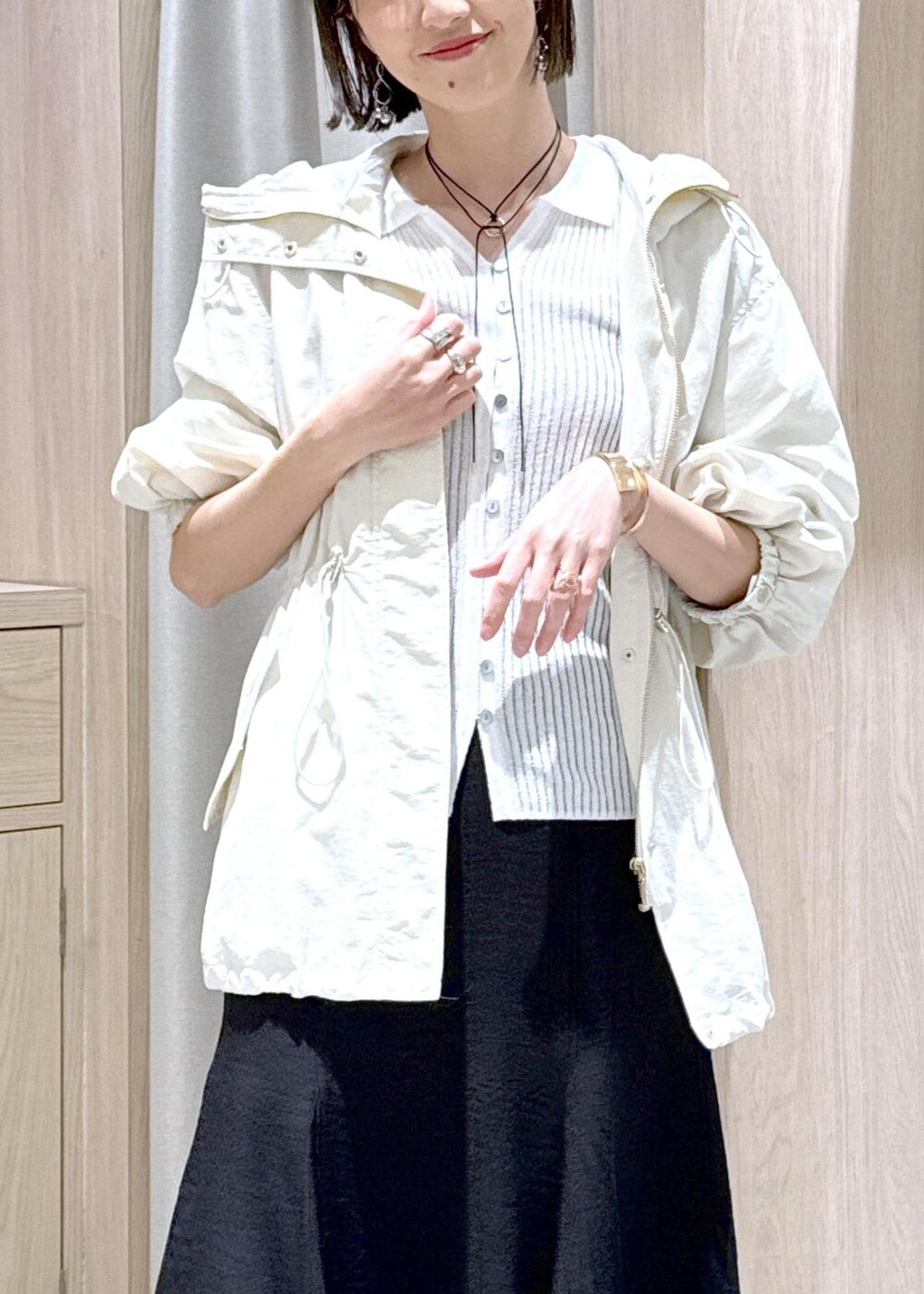 シルバー系のパンプス、ブラック系のスカート、ホワイト系のカーディガン/ボレロを着用したレディースの春コーディネートの7枚目の写真