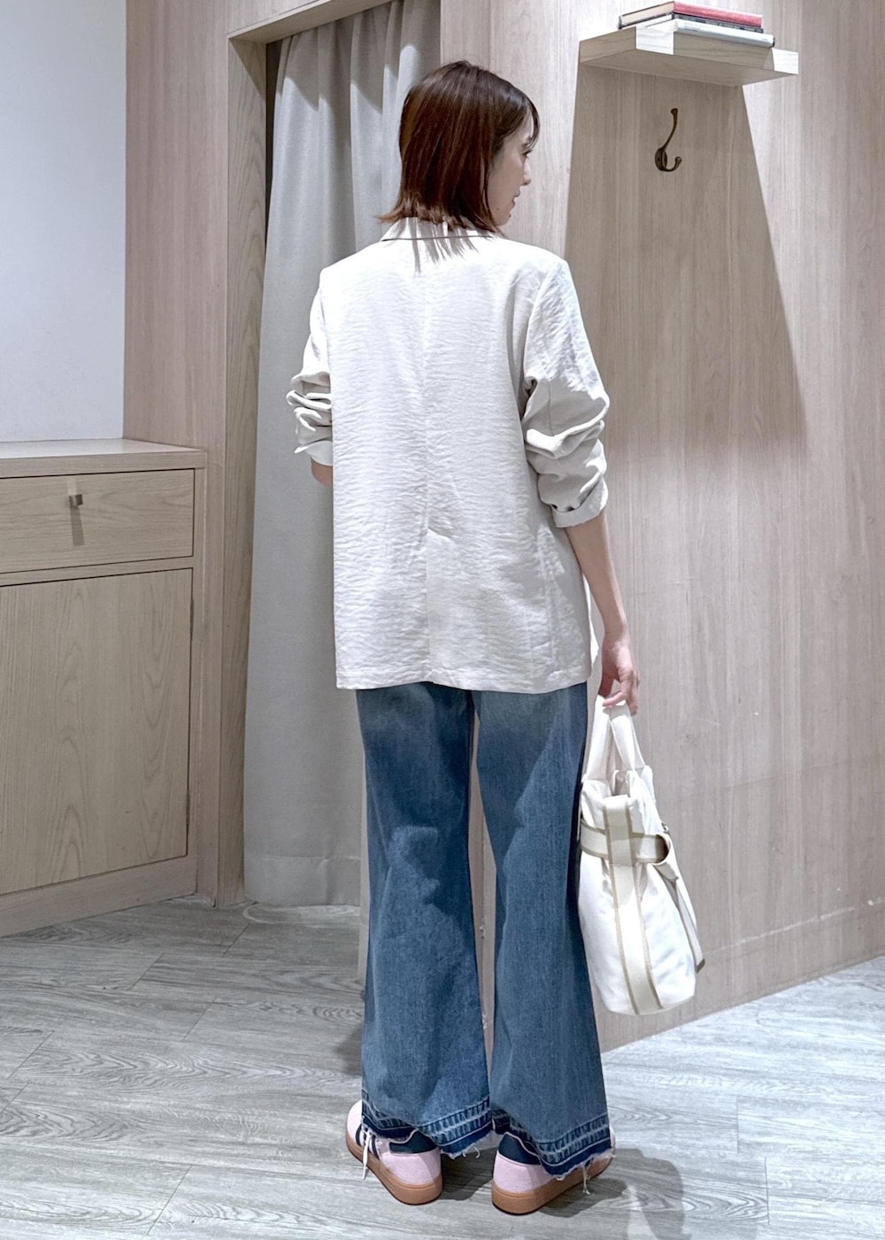 ホワイト系のトートバッグ、ブルー系のデニムパンツ、ホワイト系のシャツ/ブラウスを着用したレディースの春コーディネートの3枚目の写真
