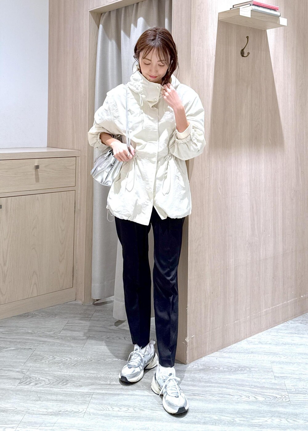 シルバー系のショルダーバッグ、ブラック系のその他パンツ、ホワイト系のマウンテンパーカーを着用したレディースの冬コーディネートの2枚目の写真