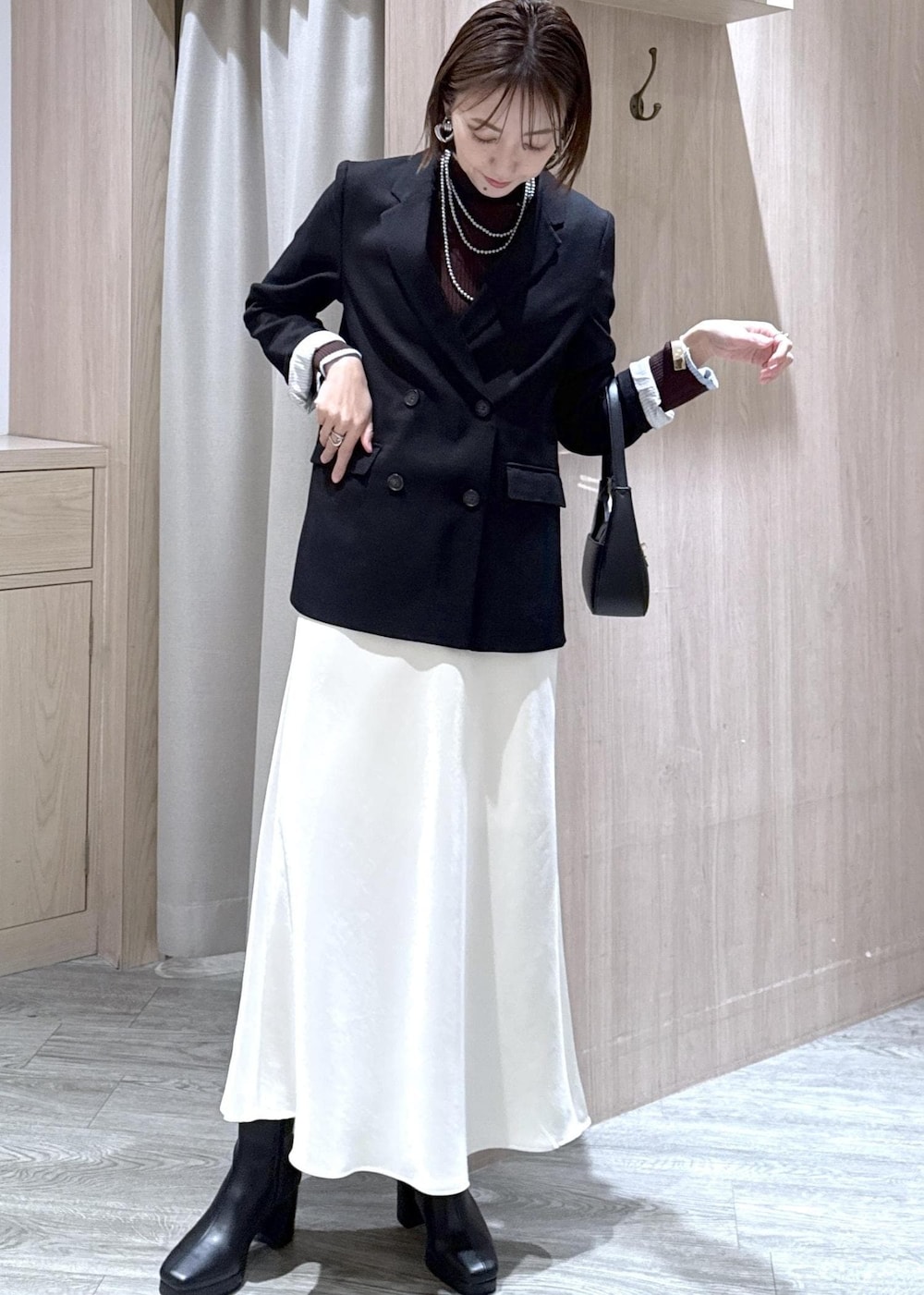 ブラック系のショルダーバッグ、ブラック系のテーラードジャケット、ブラック系のブーツを着用したレディースの冬コーディネートの4枚目の写真