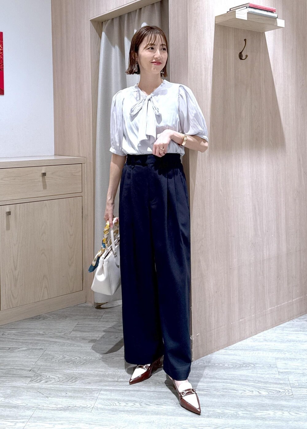 ブラウン系のパンプス、グレー系のシャツ/ブラウス、ブルー系のその他パンツを着用したレディースの春コーディネートの2枚目の写真