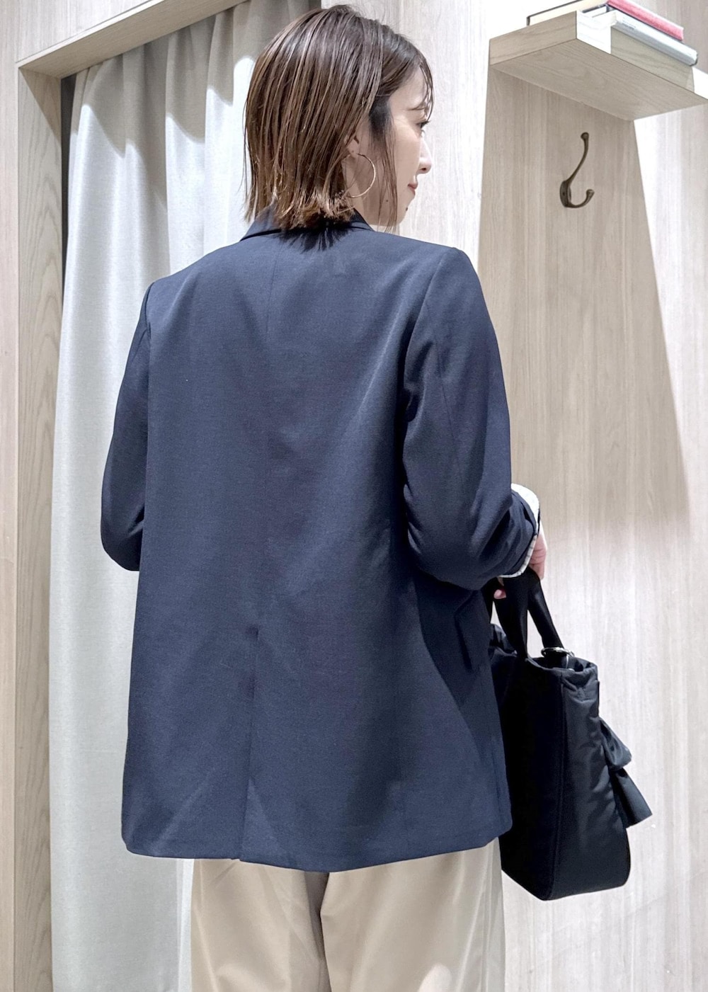 ブルー系のテーラードジャケット、ブラック系のトートバッグ、ホワイト系のカーディガン/ボレロを着用したレディースの冬コーディネートの6枚目の写真