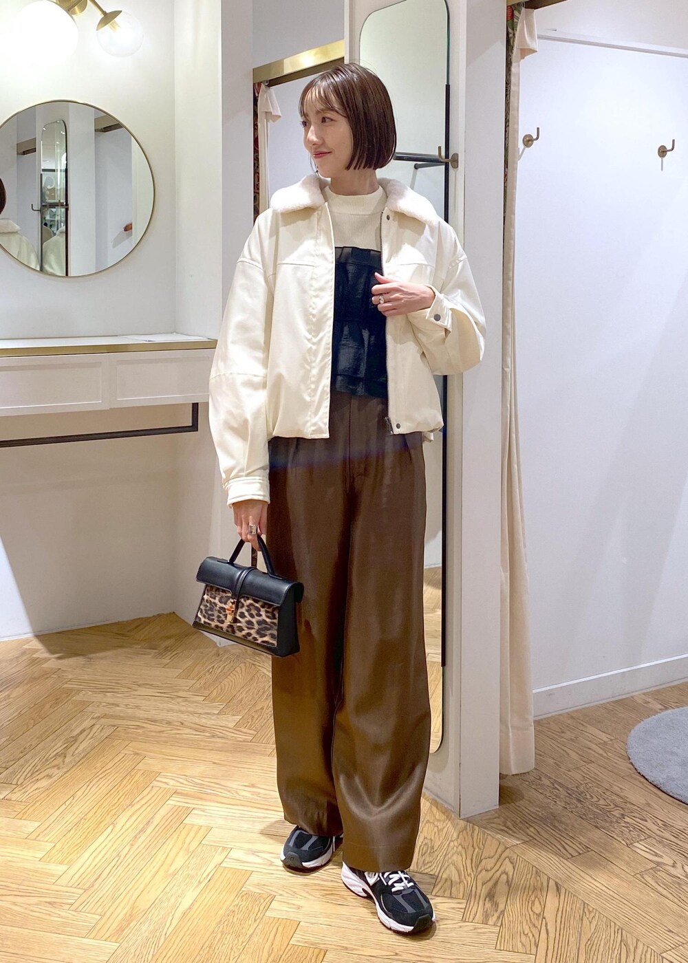ホワイト系のブルゾン、ホワイト系のニット/セーター、ブラウン系のその他パンツを着用したレディースの冬コーディネートの10枚目の写真