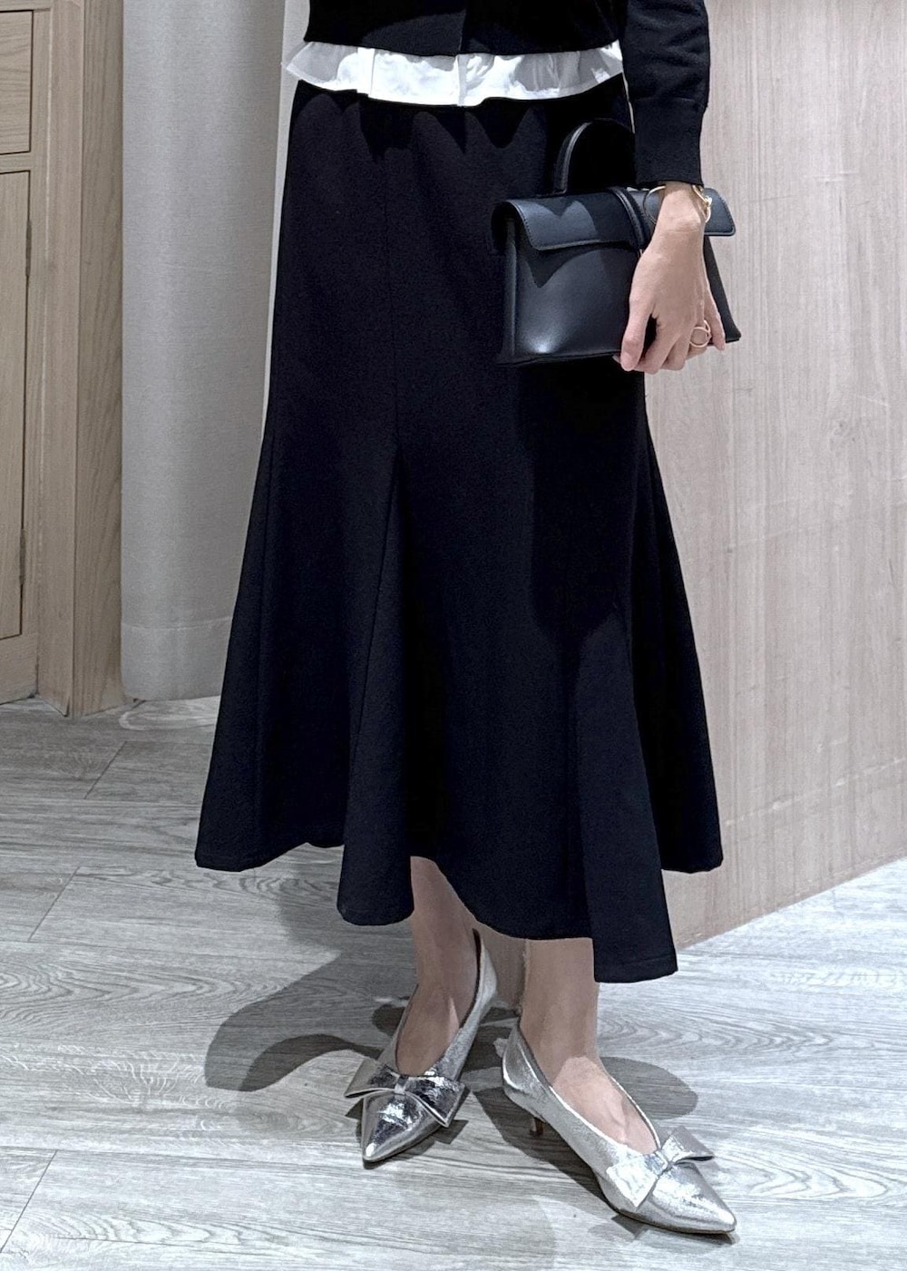 シルバー系のパンプス、ブラック系のショルダーバッグ、ブラック系のスカートを着用したレディースの冬コーディネートの5枚目の写真