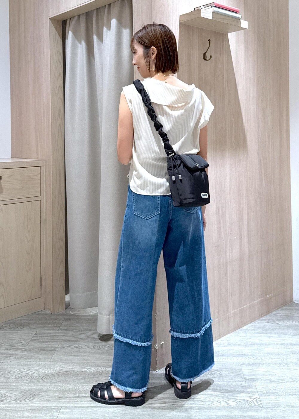 ベージュ系のキャミソール、ベージュ系のシャツ/ブラウス、ブルー系のデニムパンツを着用したレディースの夏コーディネートの3枚目の写真