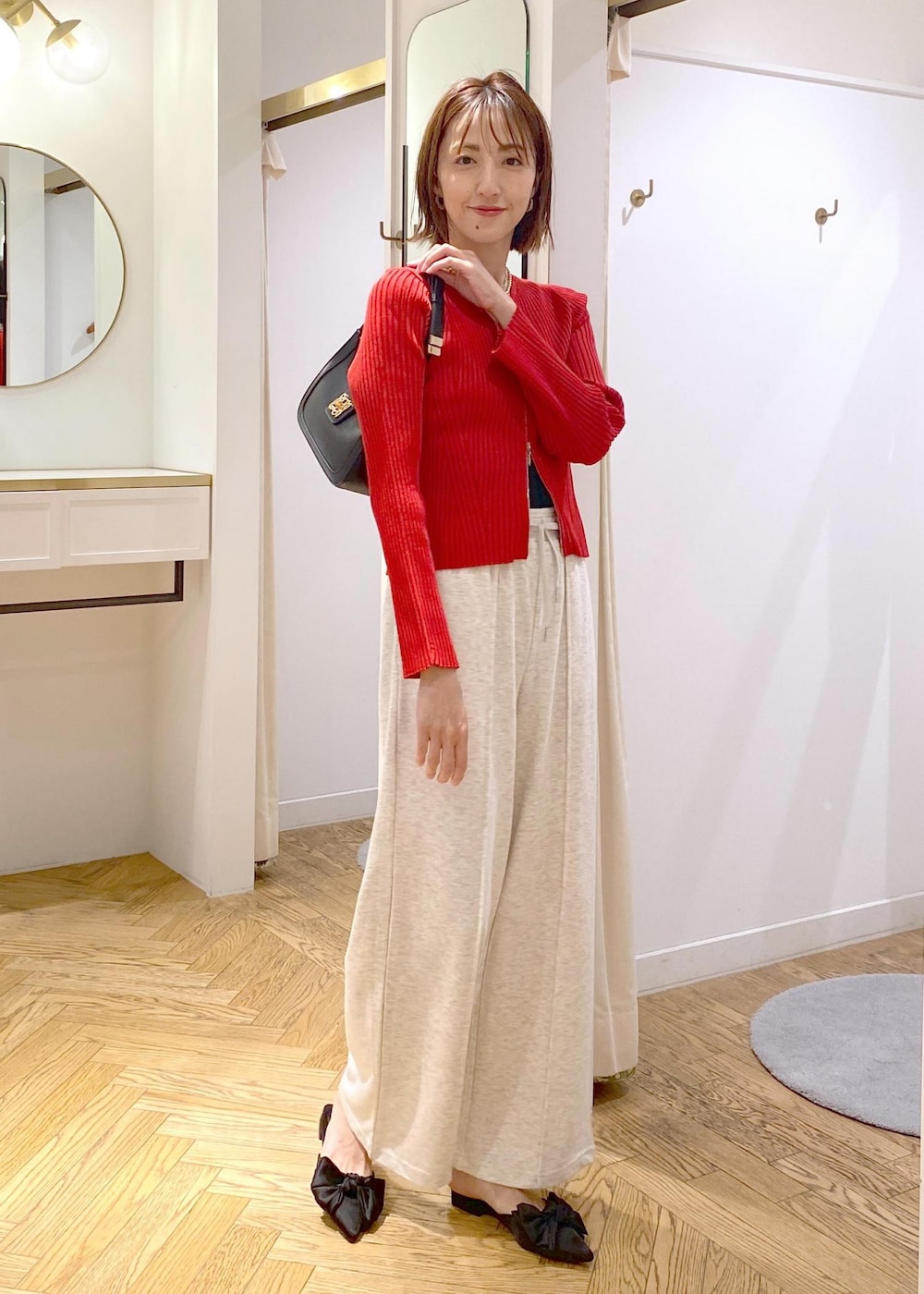 ブラック系のキャミソール、ブラック系のハンドバッグ、ホワイト系のその他パンツを着用したレディースの秋コーディネートの9枚目の写真