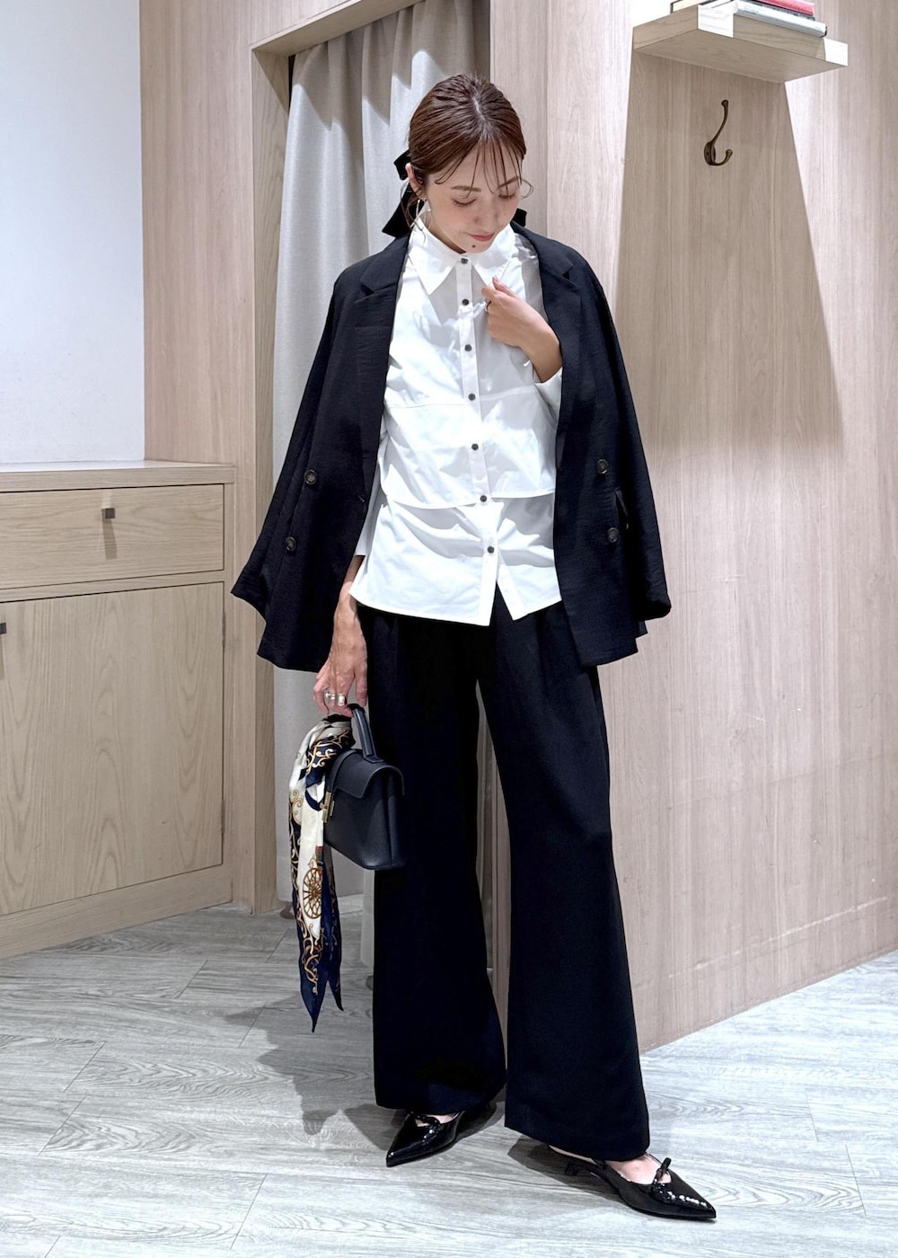 ブラック系のショルダーバッグ、ブラック系のパンプス、ブラック系のテーラードジャケットを着用したレディースの夏コーディネートの4枚目の写真