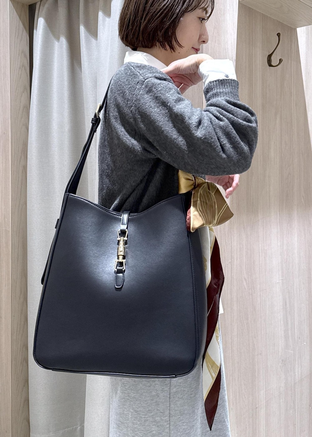 ブラック系のトートバッグ、グレー系のスカート、ホワイト系のシャツ/ブラウスを着用したレディースの秋コーディネートの9枚目の写真