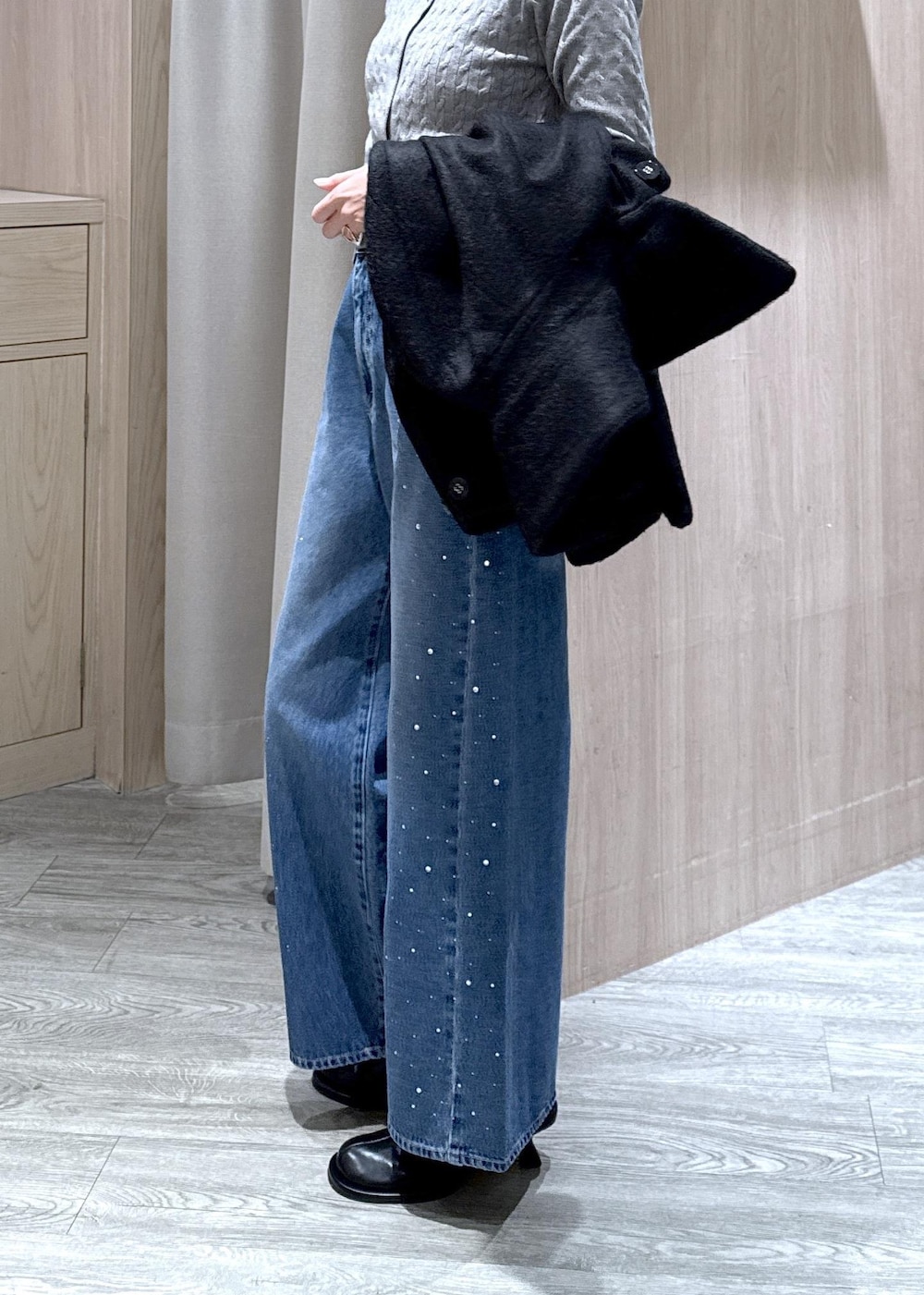 グレー系のカーディガン/ボレロ、ブラック系のブルゾン、ブルー系のデニムパンツを着用したレディースの秋コーディネートの9枚目の写真