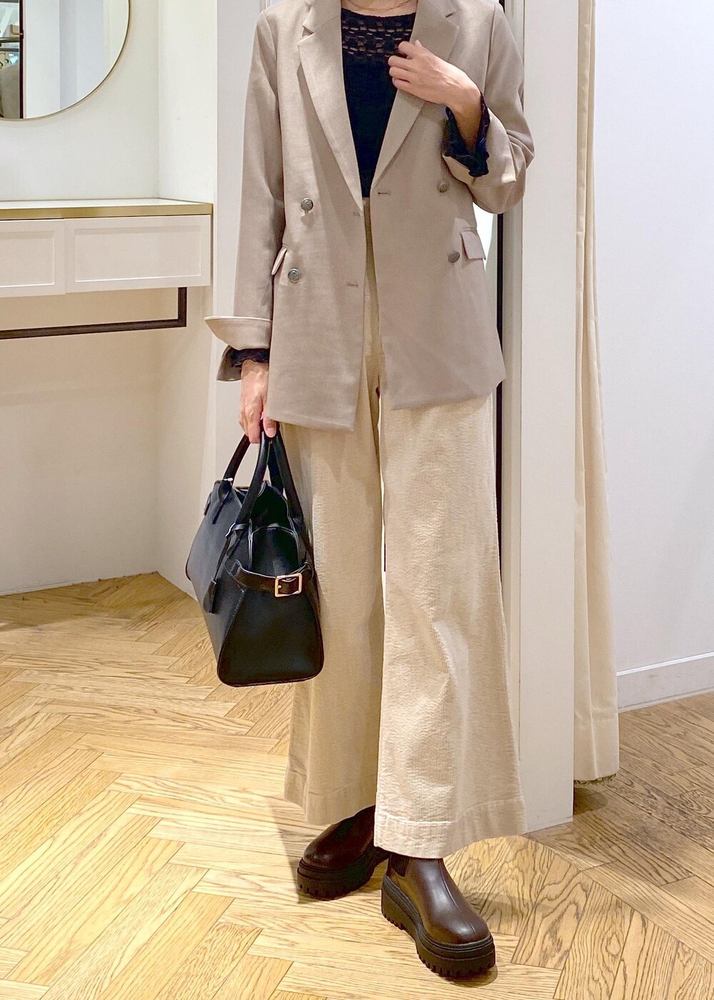 ブラック系のトートバッグ、ブラウン系のブーツ、ブラック系のTシャツ/カットソーを着用したレディースの秋コーディネートの5枚目の写真