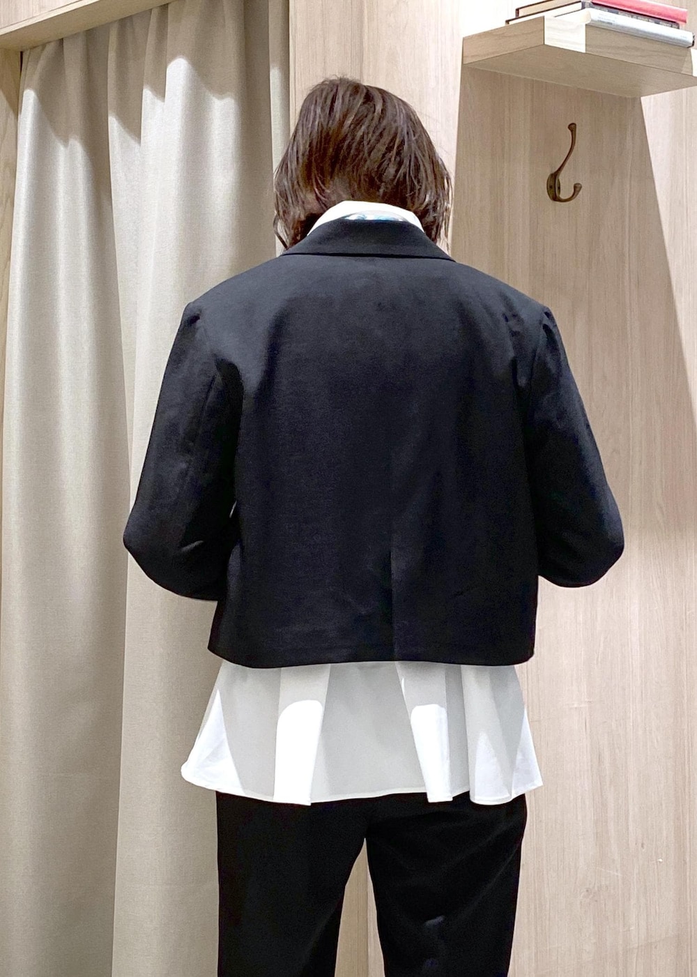 ブラック系のパンプス、ホワイト系のカーディガン/ボレロ、ブラック系のハンドバッグを着用したレディースの冬コーディネートの7枚目の写真