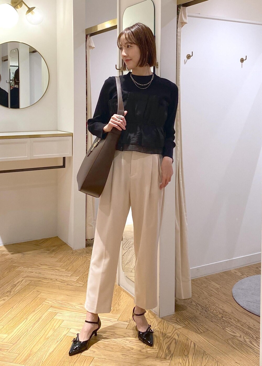 ブラック系のパンプス、ブラック系のニット/セーター、ベージュ系のその他パンツを着用したレディースの冬コーディネートの2枚目の写真