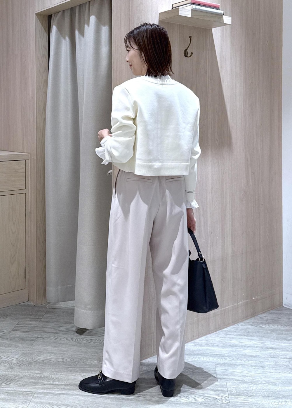 ブラック系のショルダーバッグ、ホワイト系のシャツ/ブラウス、ベージュ系のその他パンツを着用したレディースの冬コーディネートの2枚目の写真