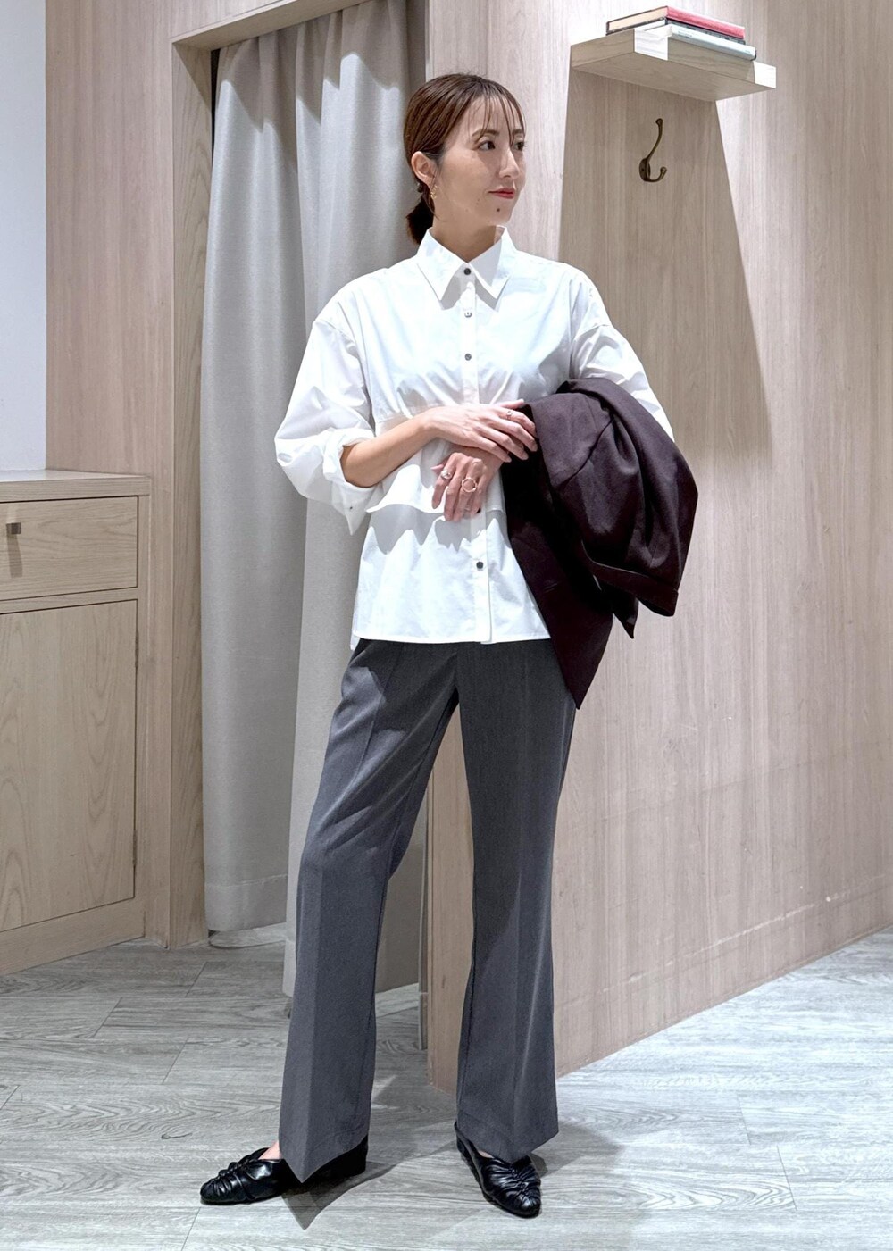 ブラック系のハンドバッグ、ブラック系のパンプス、ホワイト系のシャツ/ブラウスを着用したレディースの秋コーディネートの7枚目の写真