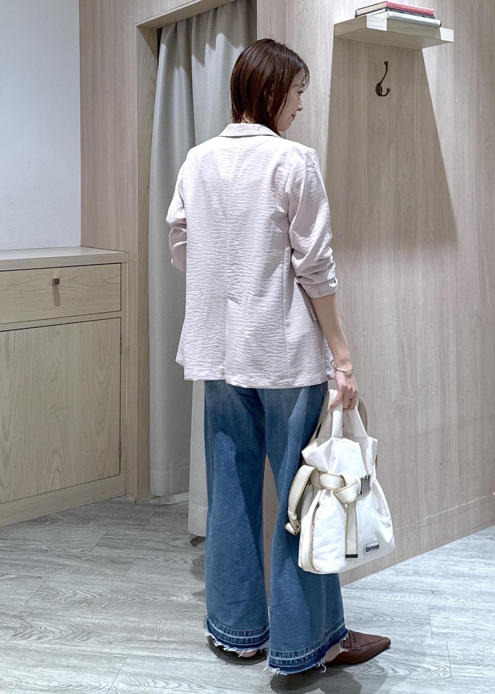 ホワイト系のトートバッグ、ブルー系のデニムパンツ、ブラック系のニット/セーターを着用したレディースの春コーディネートの3枚目の写真