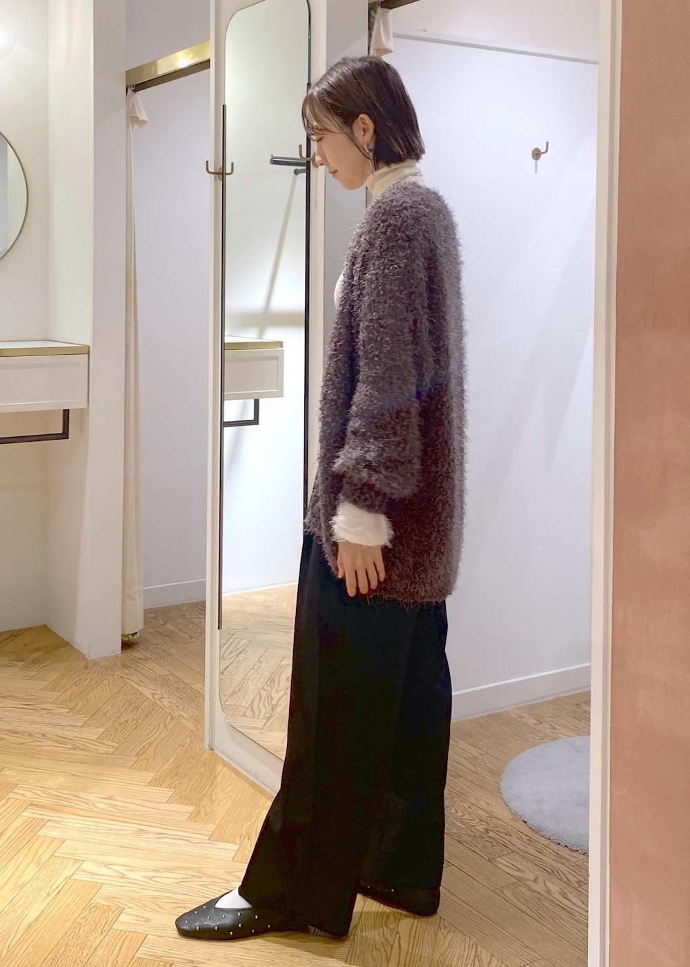 ブラック系のバレエシューズ、グレー系のカーディガン/ボレロ、ホワイト系のニット/セーターを着用したレディースの秋コーディネートの2枚目の写真