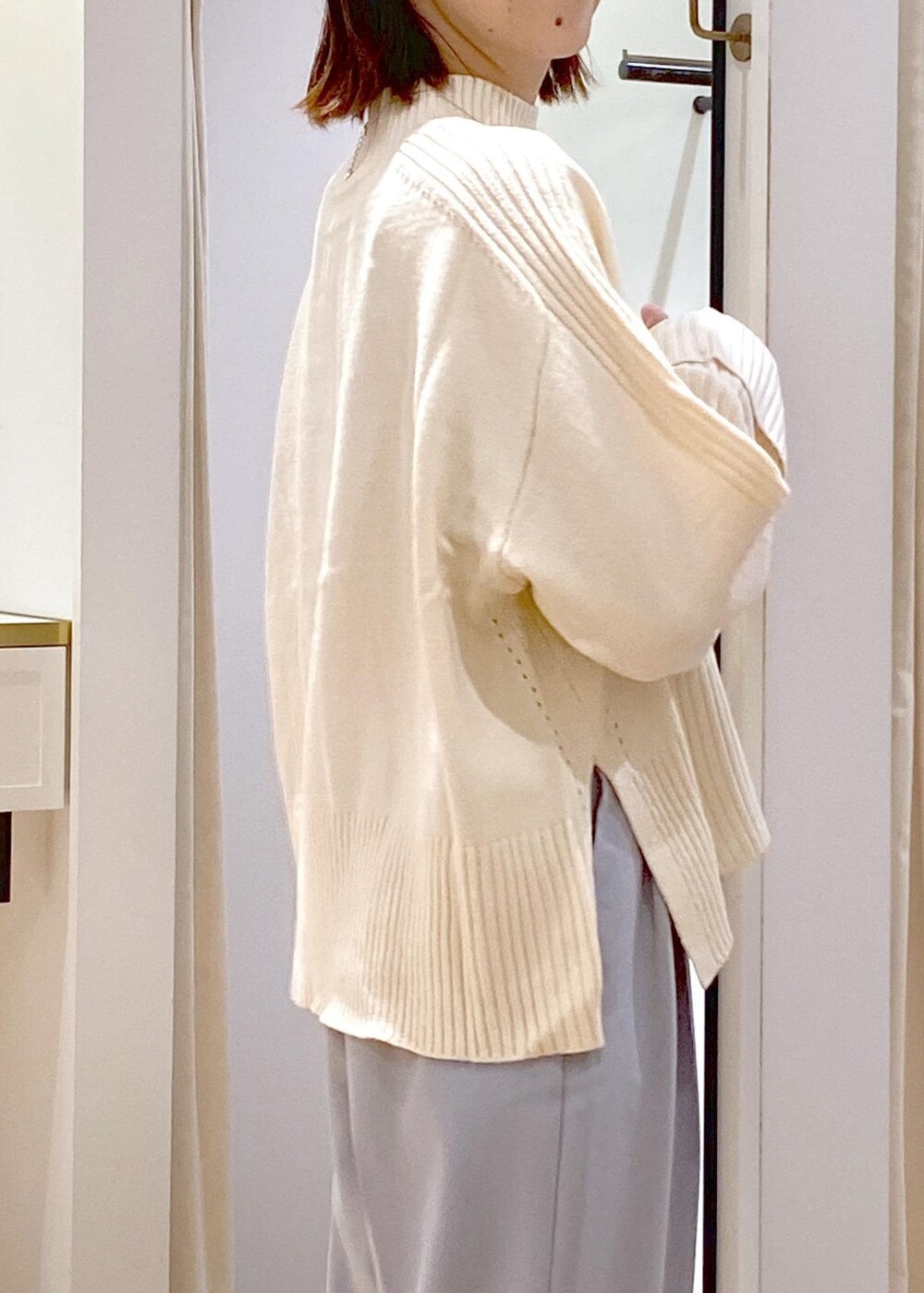 シルバー系のパンプス、ブラック系のショルダーバッグ、ブルー系のスラックスを着用したレディースの秋コーディネートの7枚目の写真