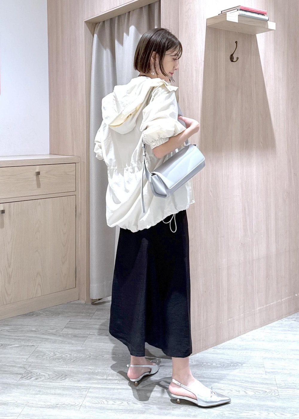 シルバー系のパンプス、ブラック系のスカート、ホワイト系のカーディガン/ボレロを着用したレディースの春コーディネートの4枚目の写真