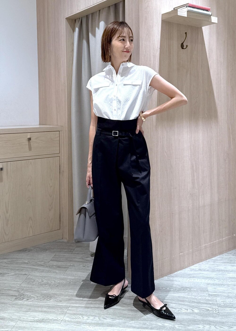 グレー系のハンドバッグ、ブラック系のパンプス、ベージュ系のキャミソールを着用したレディースの夏コーディネートの5枚目の写真