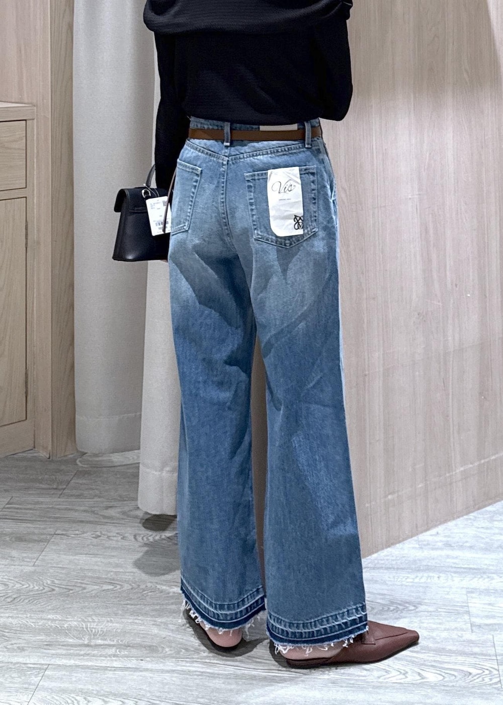 ブラック系のショルダーバッグ、ブルー系のデニムパンツ、ブラック系のTシャツ/カットソーを着用したレディースの春コーディネートの4枚目の写真