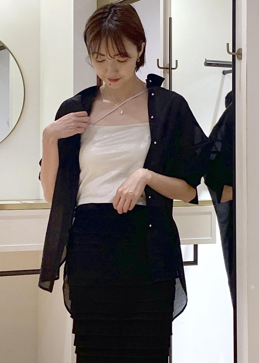 ブラック系のサンダル、ブラック系のスカート、シルバー系のキャミソールを着用したレディースの夏コーディネートの3枚目の写真