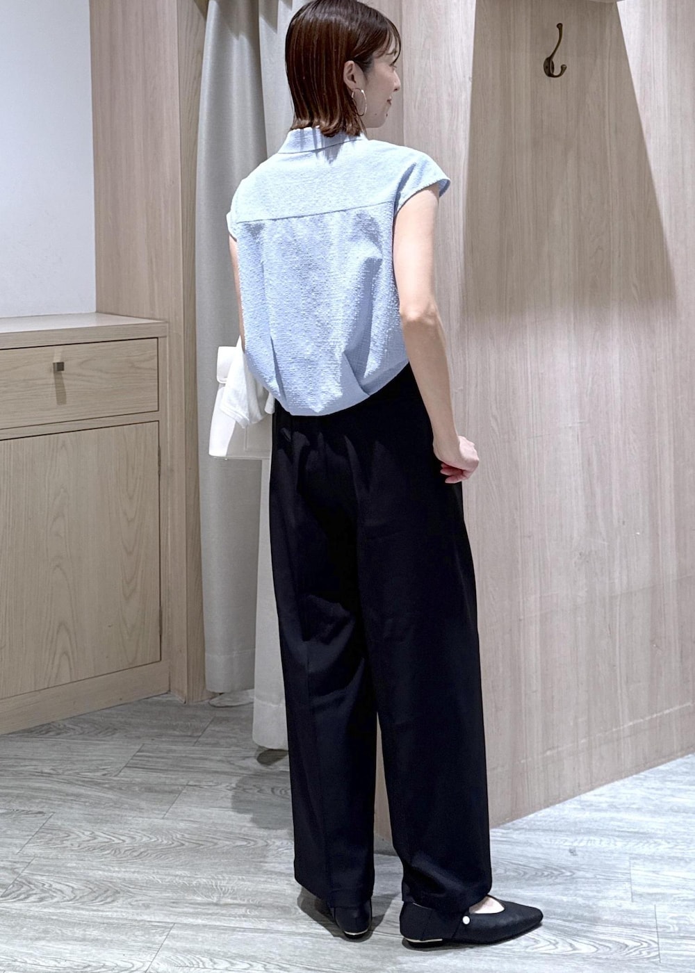 ブラック系のパンプス、ホワイト系のハンドバッグ、ホワイト系のカーディガン/ボレロを着用したレディースの春コーディネートの3枚目の写真