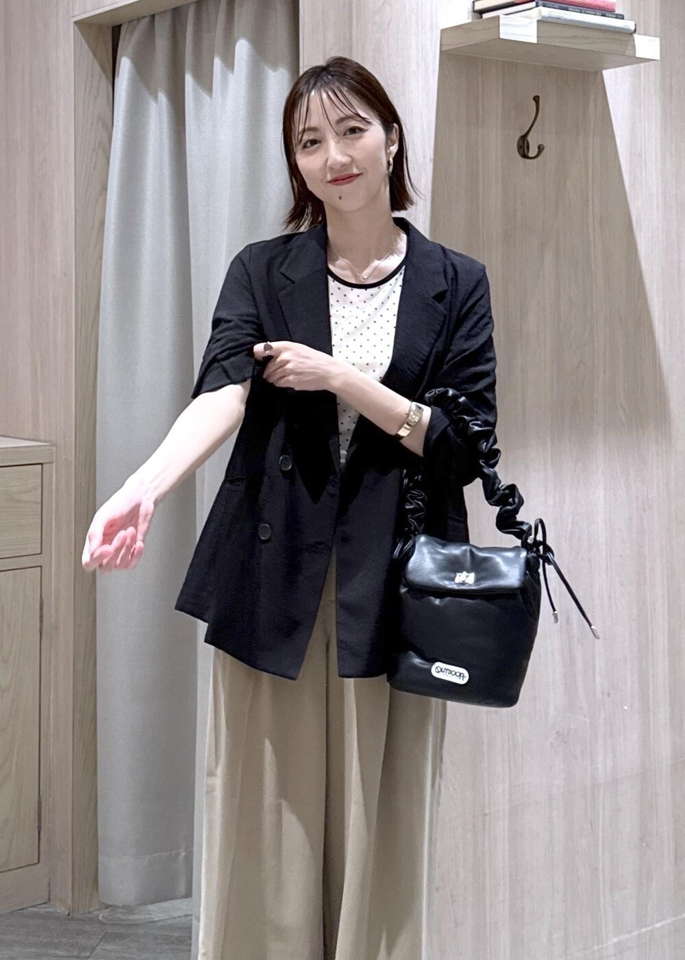 ベージュ系のその他パンツ、ブラック系のテーラードジャケット、ブラック系のショルダーバッグを着用したレディースの春コーディネートの9枚目の写真