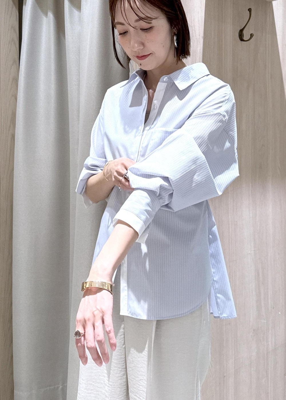 ベージュ系のキャミソール、ブラック系のショルダーバッグ、ブルー系のシャツ/ブラウスを着用したレディースの春コーディネートの8枚目の写真