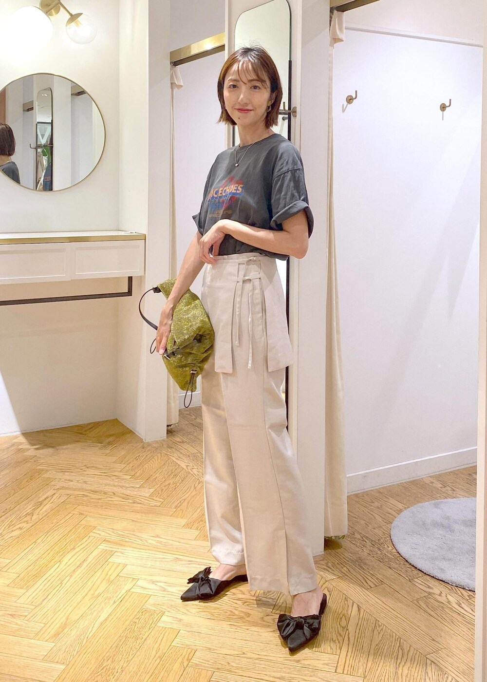 ゴールド系のショルダーバッグ、ブラック系のサンダル、グレー系のTシャツ/カットソーを着用したレディースの夏コーディネートの2枚目の写真