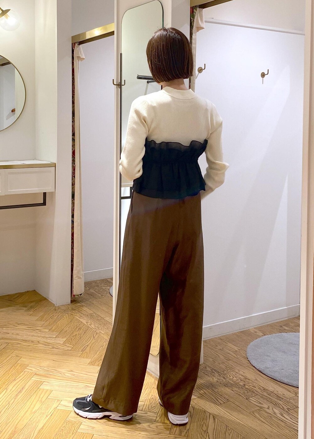 ホワイト系のブルゾン、ホワイト系のニット/セーター、ブラウン系のその他パンツを着用したレディースの冬コーディネートの9枚目の写真