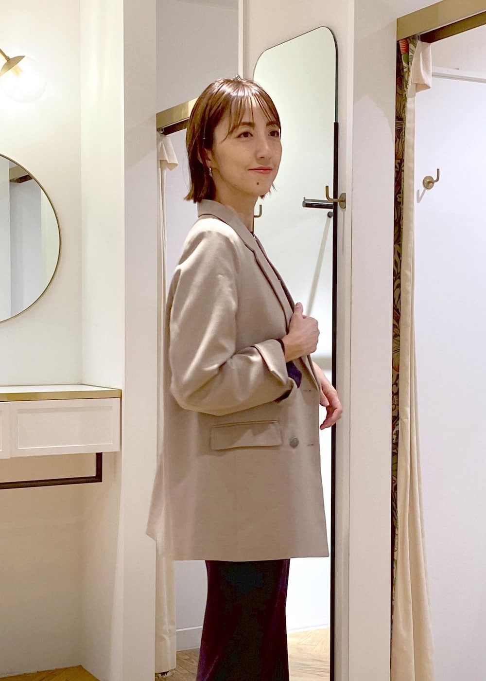 ブラック系のショルダーバッグ、ブラック系のブーツ、ベージュ系のテーラードジャケットを着用したレディースの秋コーディネートの4枚目の写真