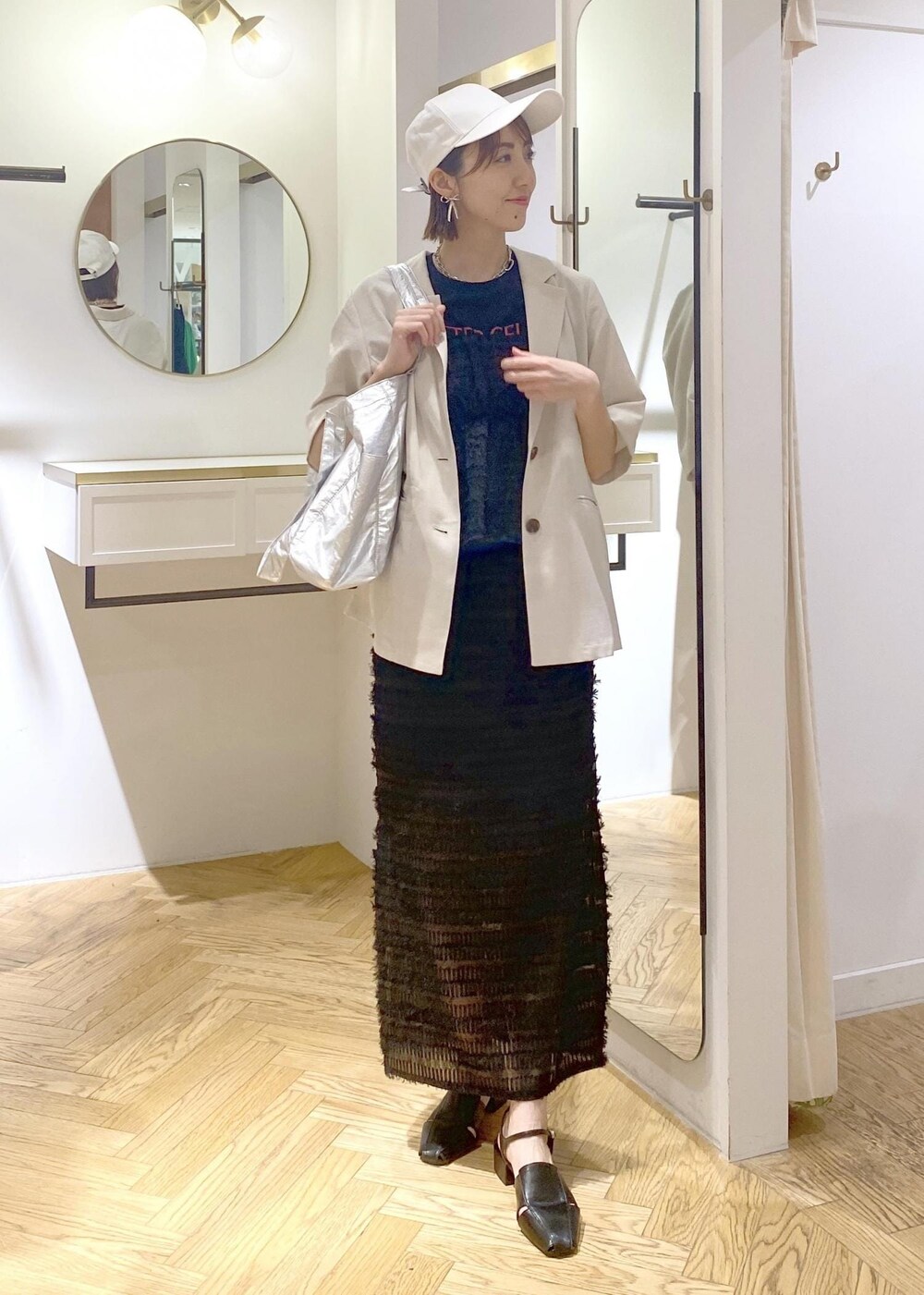 ブラック系のサンダル、ブラック系のスカート、ブラック系のキャミソールを着用したレディースの春コーディネートの6枚目の写真