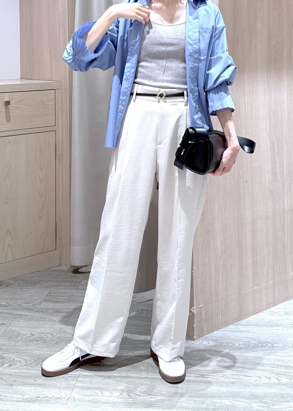 グレー系のタンクトップ、ブルー系のシャツ/ブラウス、ブラック系のショルダーバッグを着用したレディースの春コーディネートの6枚目の写真