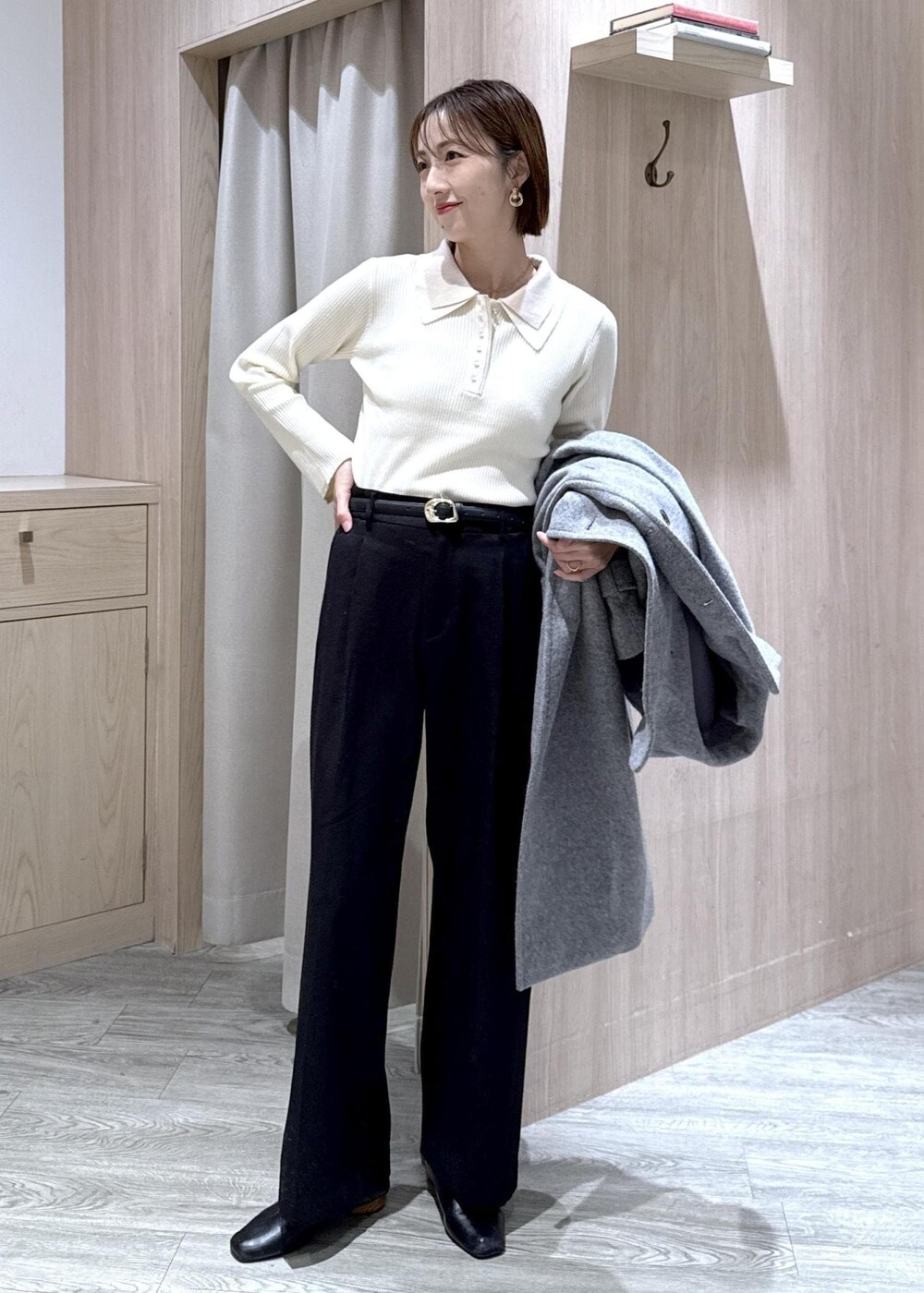 ホワイト系のニット/セーター、グレー系のその他アウター、ブラック系のスラックスを着用したレディースの冬コーディネートの5枚目の写真