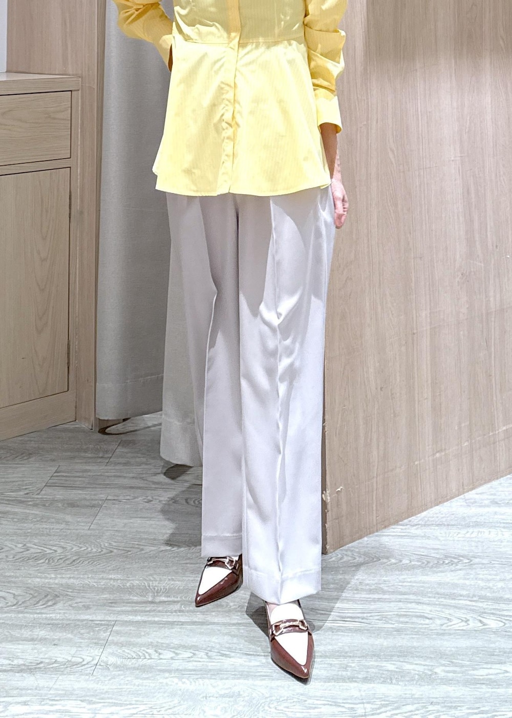 ベージュ系のショルダーバッグ、ブラウン系のパンプス、イエロー系のシャツ/ブラウスを着用したレディースの春コーディネートの4枚目の写真