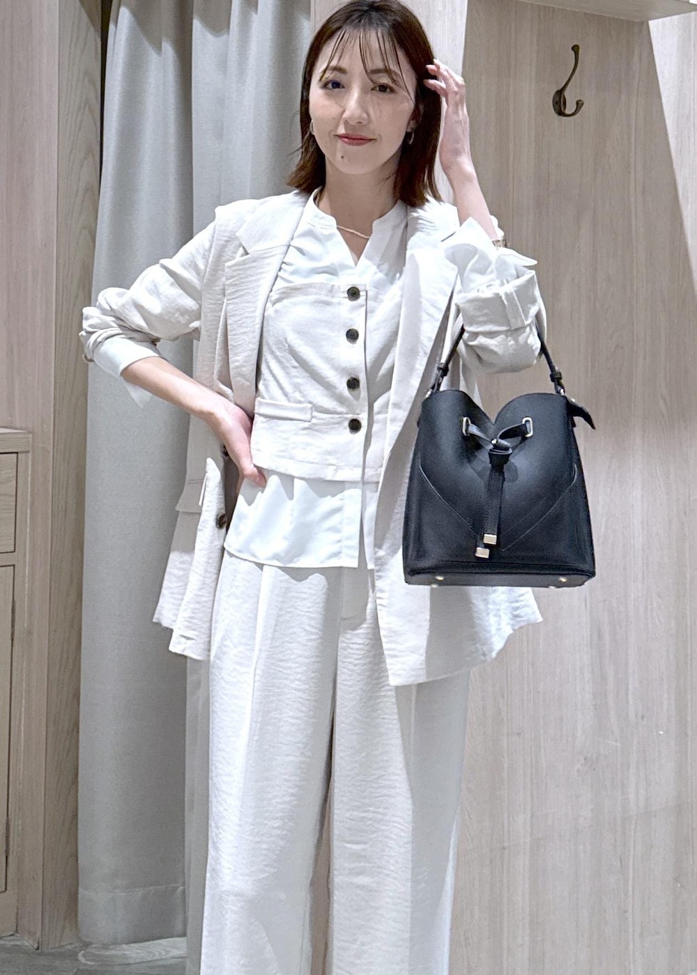ブラック系のショルダーバッグ、ブラック系のパンプス、ホワイト系のシャツ/ブラウスを着用したレディースの春コーディネートの3枚目の写真