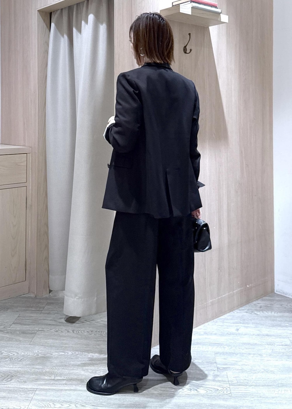 ブラック系のスラックス、ブラック系のテーラードジャケット、ブラック系のショルダーバッグを着用したレディースの冬コーディネートの10枚目の写真