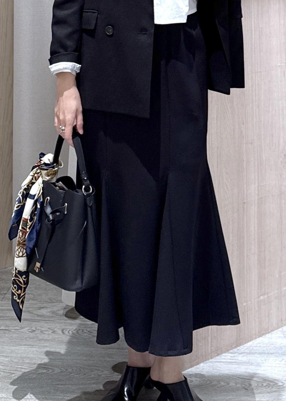 ブラック系のショルダーバッグ、ブラック系のスカート、ブラック系のテーラードジャケットを着用したレディースの冬コーディネートの5枚目の写真