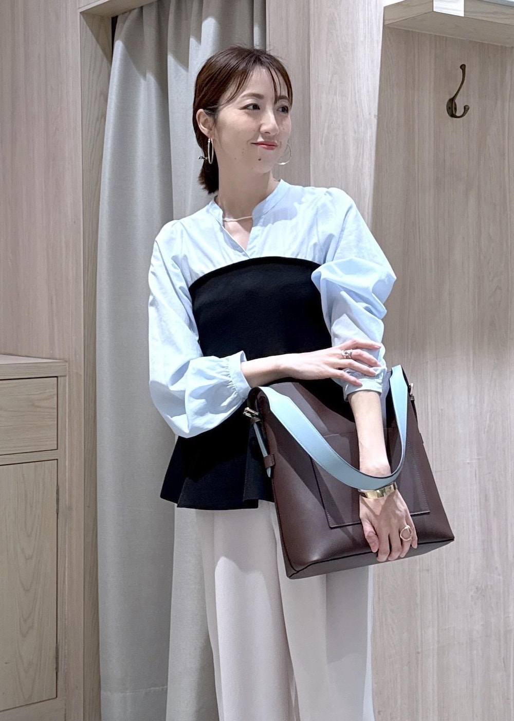 ブラウン系のトートバッグ、ベージュ系のその他パンツ、ブラック系のシャツ/ブラウスを着用したレディースの春コーディネートの6枚目の写真