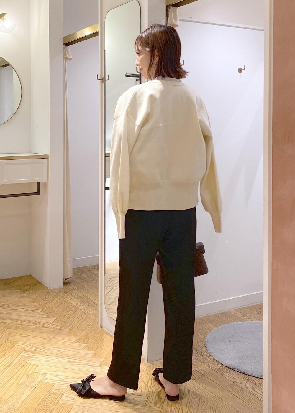 ブラウン系のショルダーバッグ、ブラック系のサンダル、ブラック系のスラックスを着用したレディースの秋コーディネートの3枚目の写真