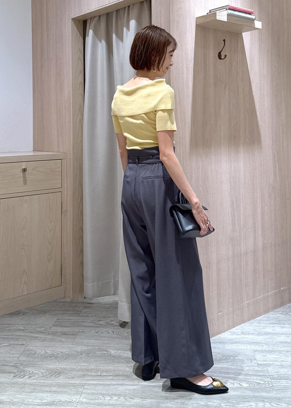 ブラック系のショルダーバッグ、ブラック系のバレエシューズ、イエロー系のニット/セーターを着用したレディースの夏コーディネートの3枚目の写真