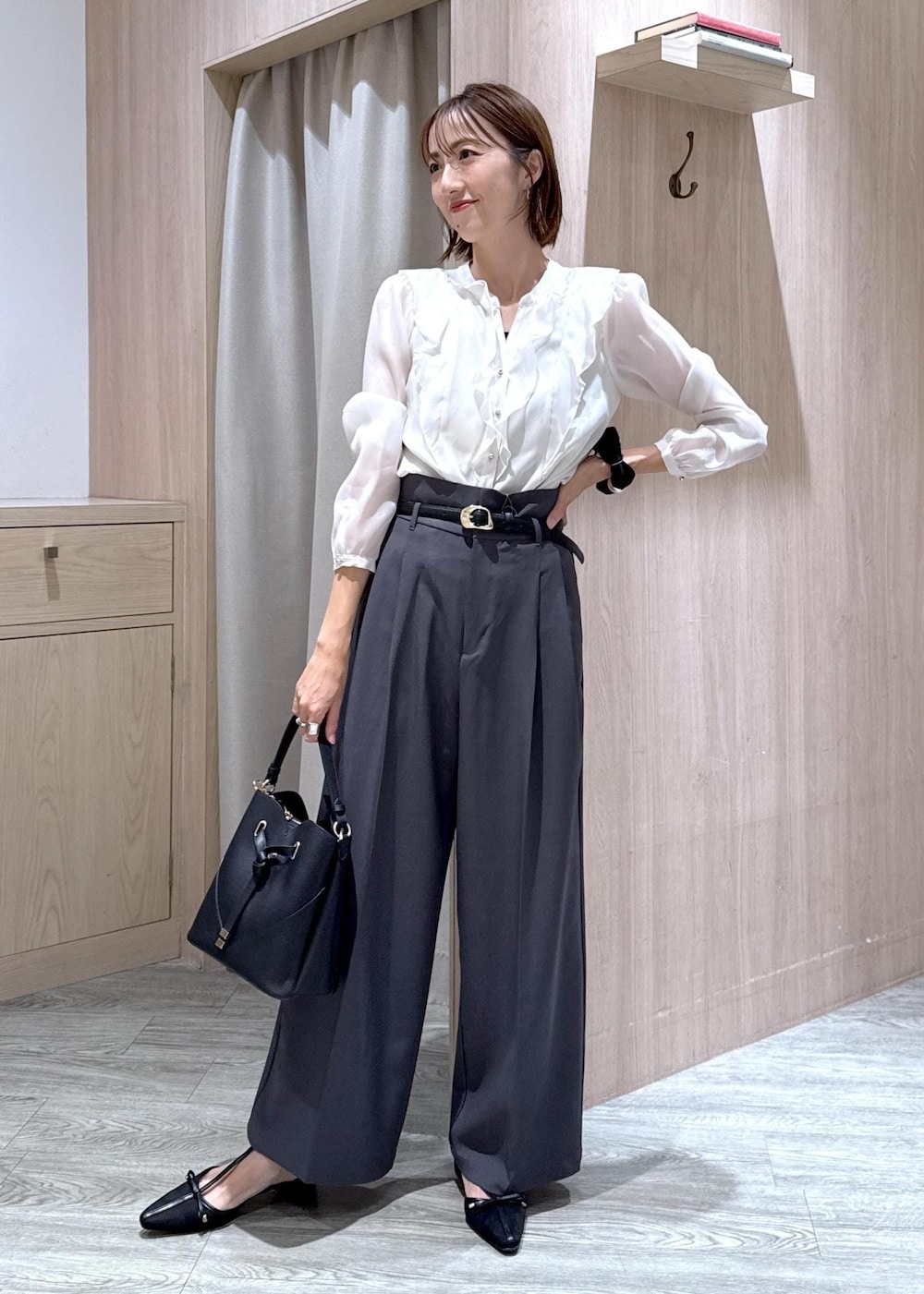 ブラック系のショルダーバッグ、グレー系のスラックス、ホワイト系のシャツ/ブラウスを着用したレディースの秋コーディネートの2枚目の写真